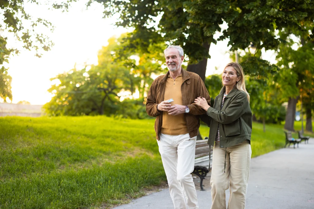 Happy senior couple walking and enjoying relaxing time together in park